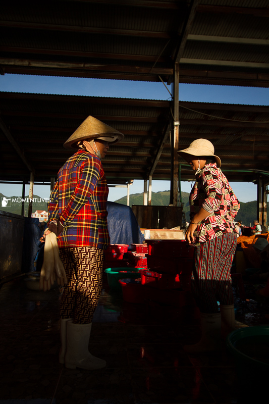 Scene of 02 ladies talking in a fish market in Nha Trang. We met them on our Nha Trang photo tour.