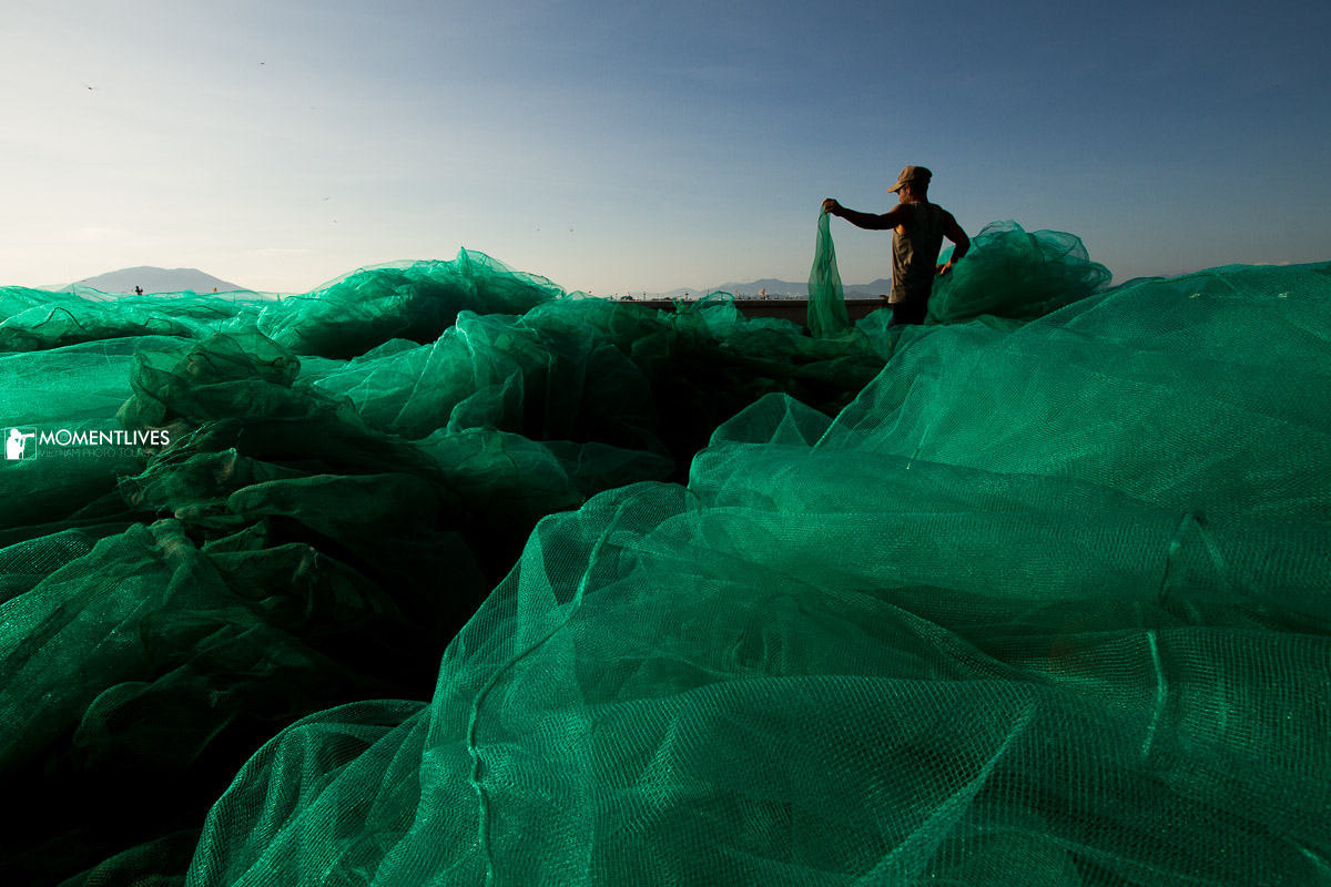Man tending fishing net in Van Gia, Nha Trang