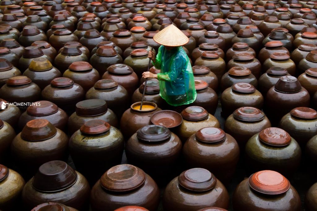 A lady stirring soy sauce in the village of Ban Yen Nhan