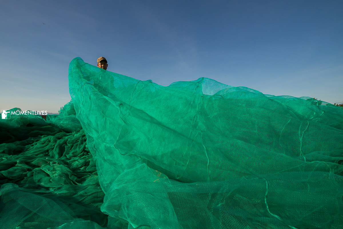 Fishermen tending a fishing net at the shoreline of Nha Trang