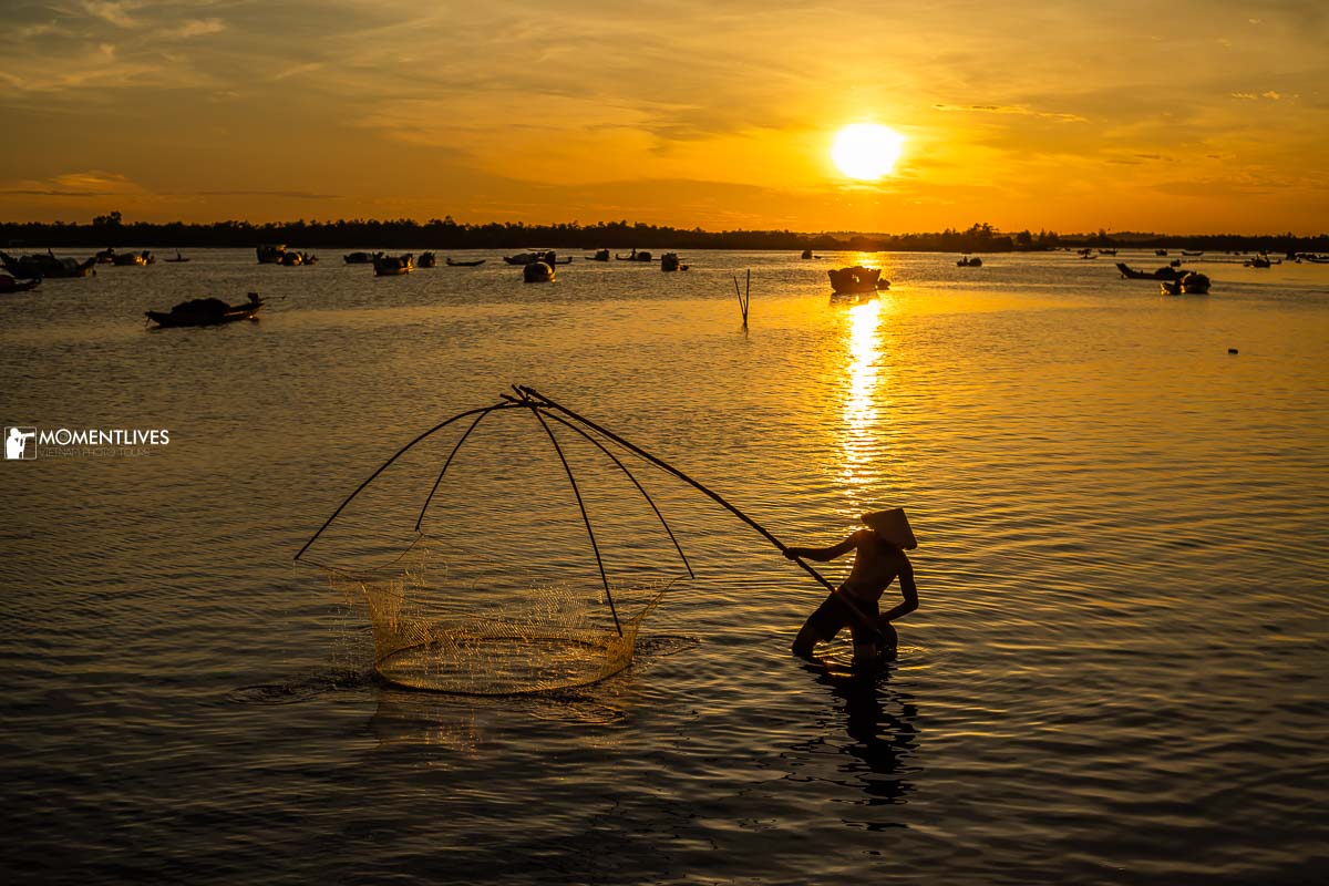 A man fishing on a lagoon with his fish trap under the sun