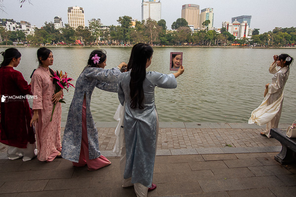 Young girls doing selfies at the Hoan Kiem lake, Old Quarter of Hanoi