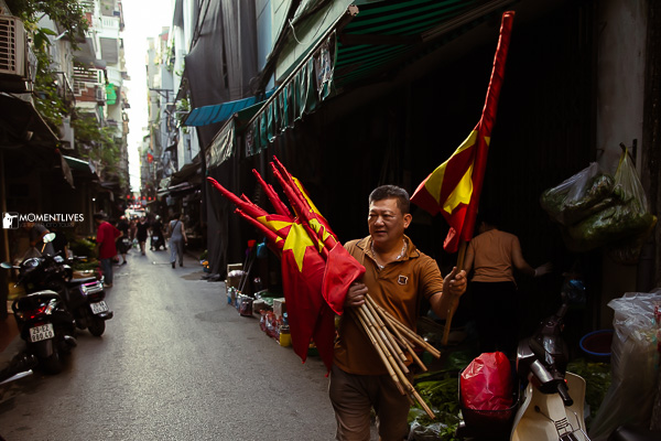 A man holding Vietnamese flags on the street of Hanoi