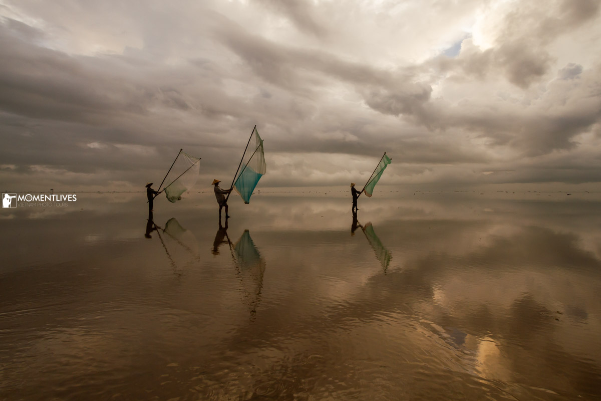 03 fishermen fishing with their bamboo traps in the Infinite Sea of Vietnam