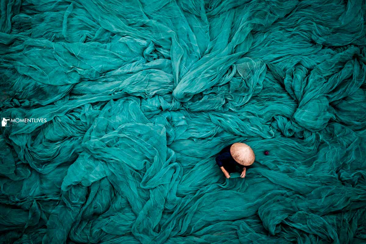 A woman sitting in a sea of fishing net