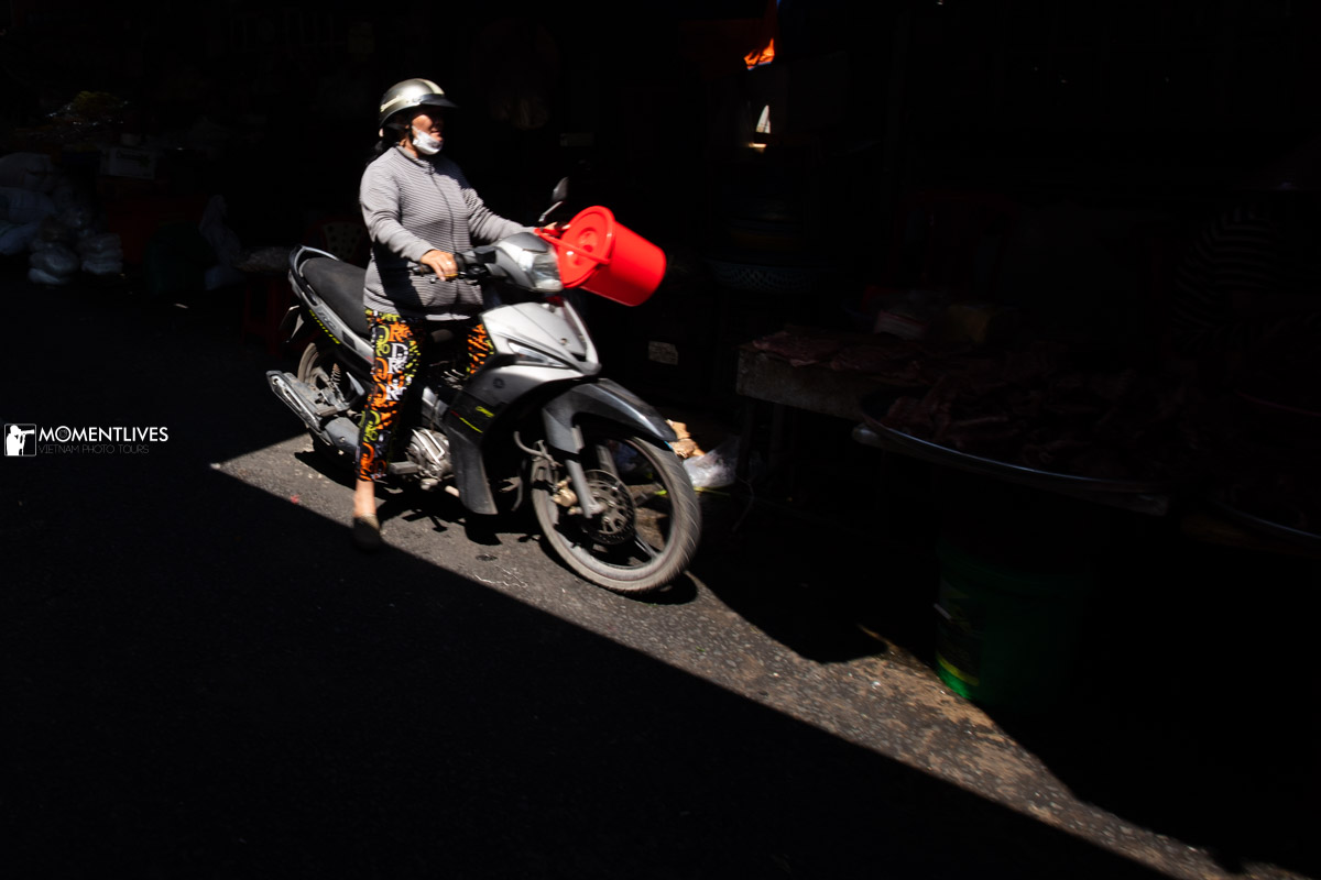 A lady riding a scooter in the market of Sa Dec