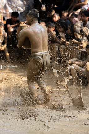 A player charges toward the opponent's goal with the mudball in hand