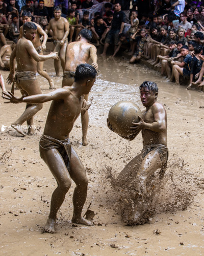 Players competing for the ball in the mudball festival