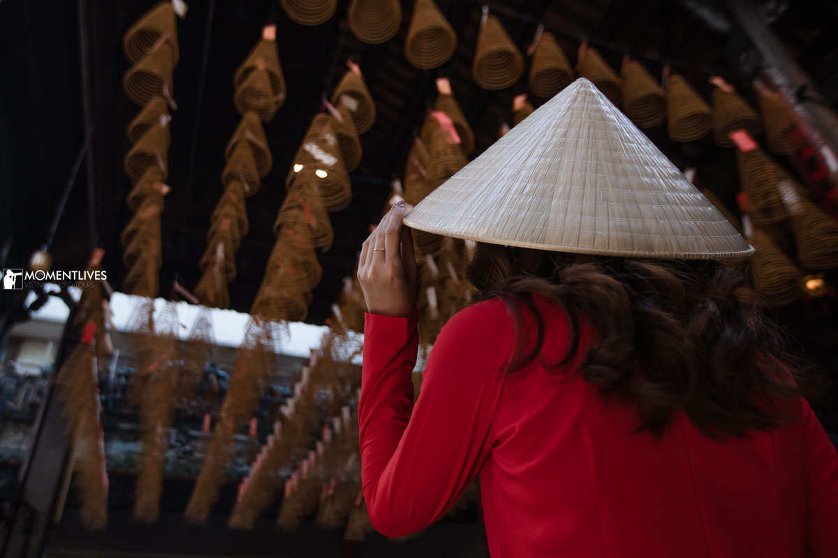 A girl in traditional Ao Dai in a temple in China town, Saigon