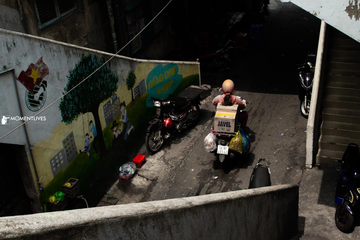 A girl riding a scooter in the old town of Saigon