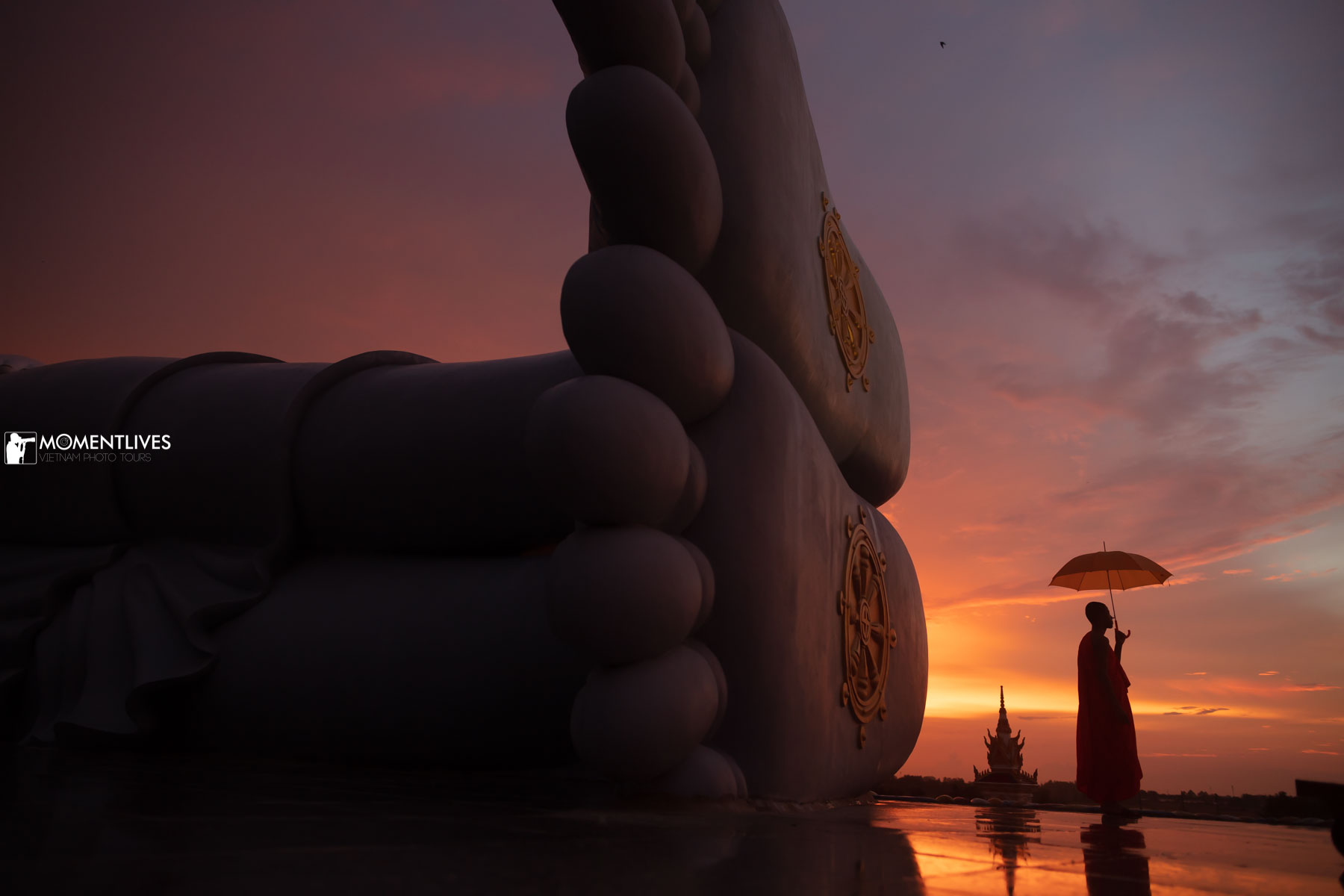 A monk walking near the gigantic feet of the Reclining Buddha